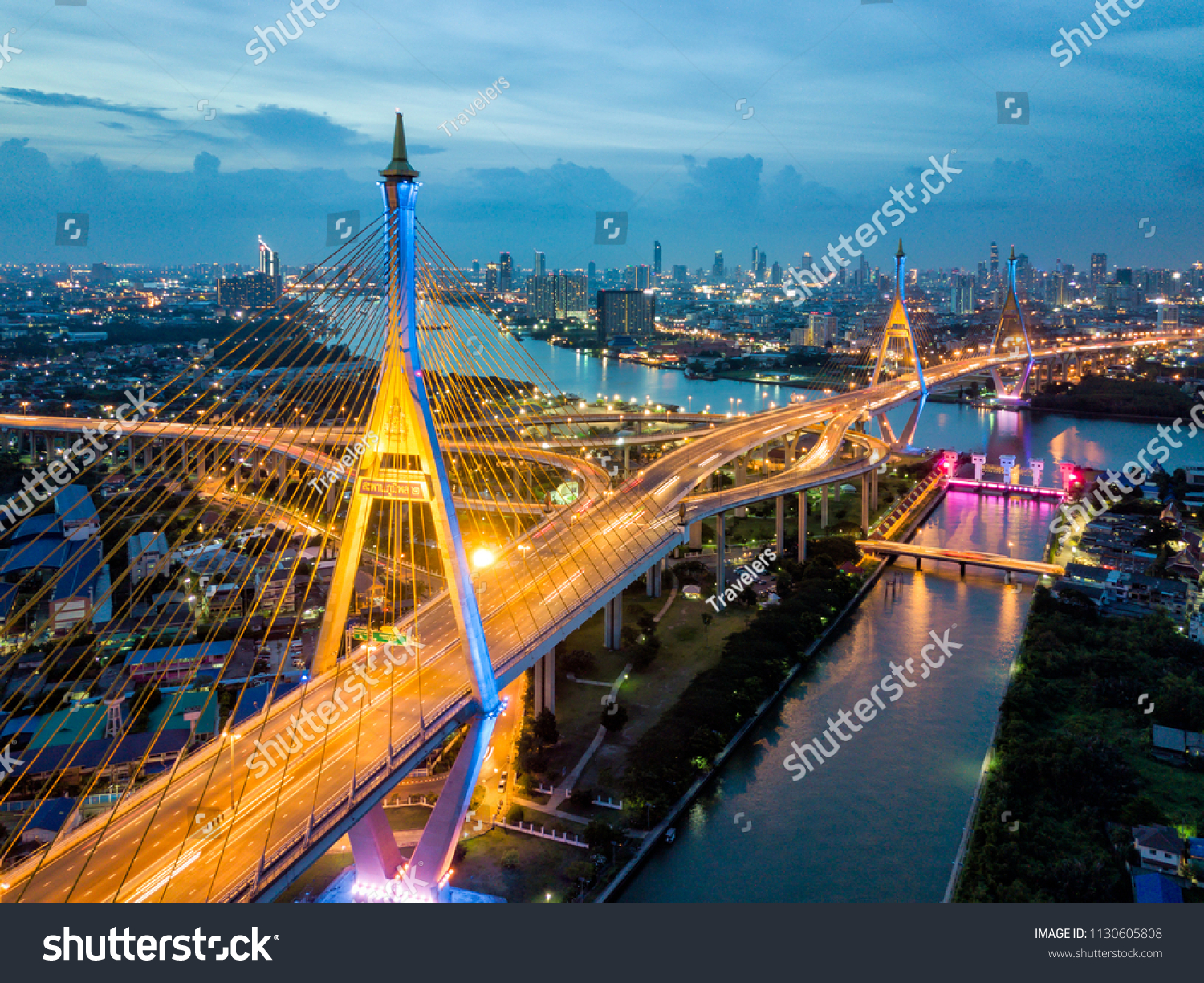 Aerial view of Bhumibol suspension bridge cross over Chao Phraya River in Bangkok city with car on the bridge at sunset sky and clouds in Bangkok Thailand.