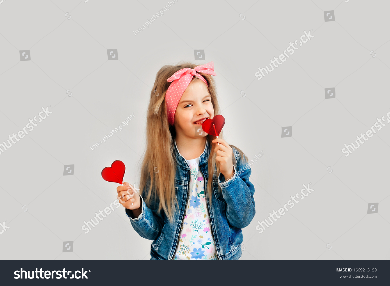 Portrait of a beautiful stylish fashionable girl in glasses with a heart-shaped lollipop on a white background free time summer vacation. Close up selective focus