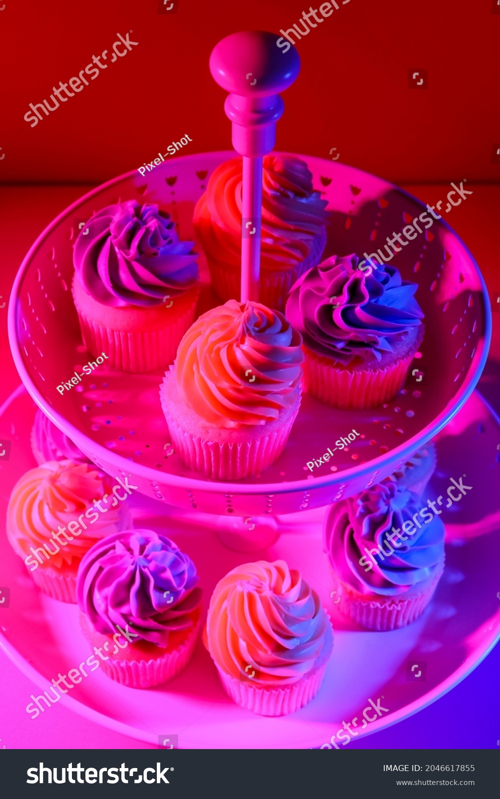 Dessert stand with tasty cupcakes on dark color background  closeup