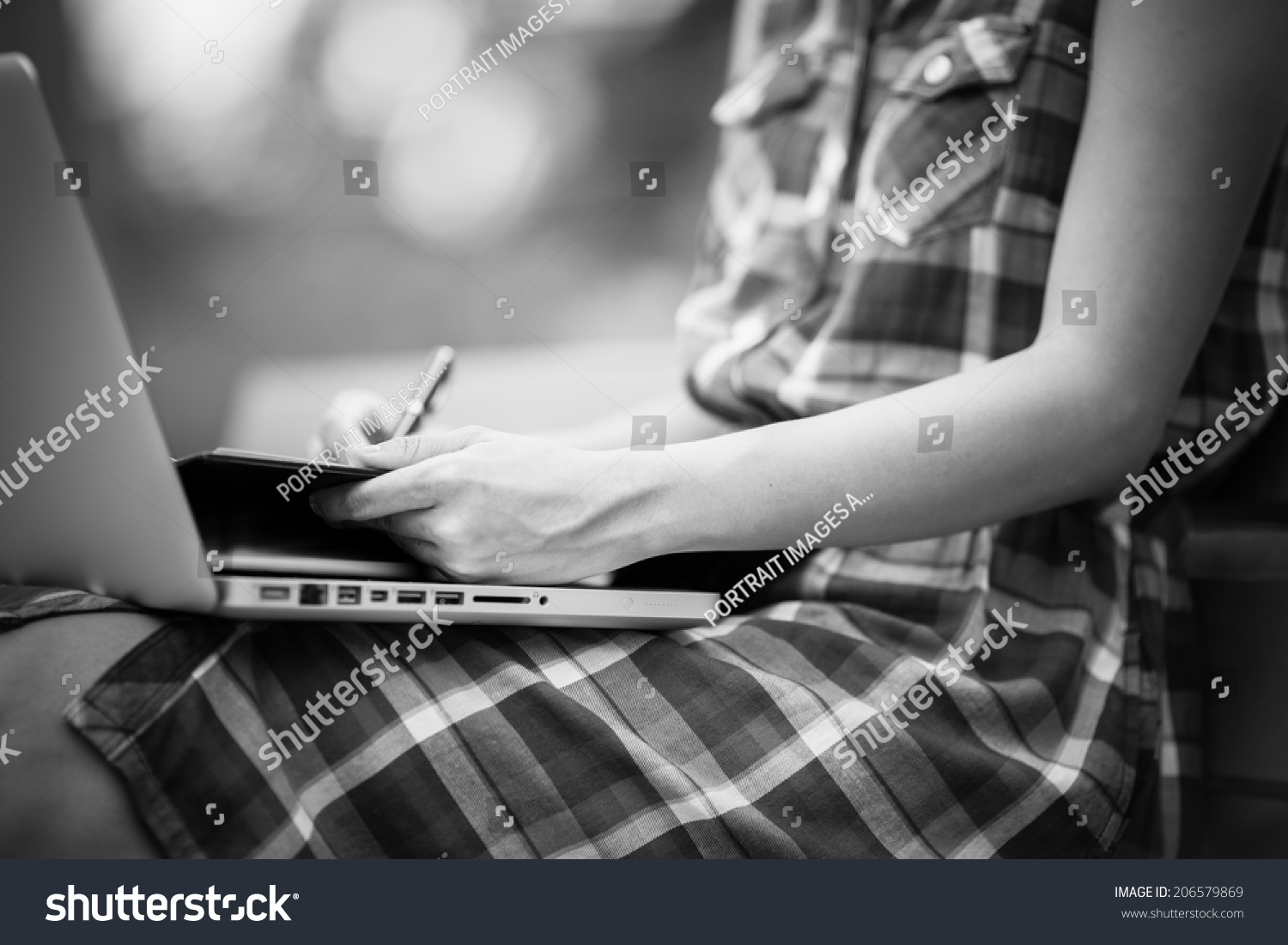 Beautiful young woman using laptop in park