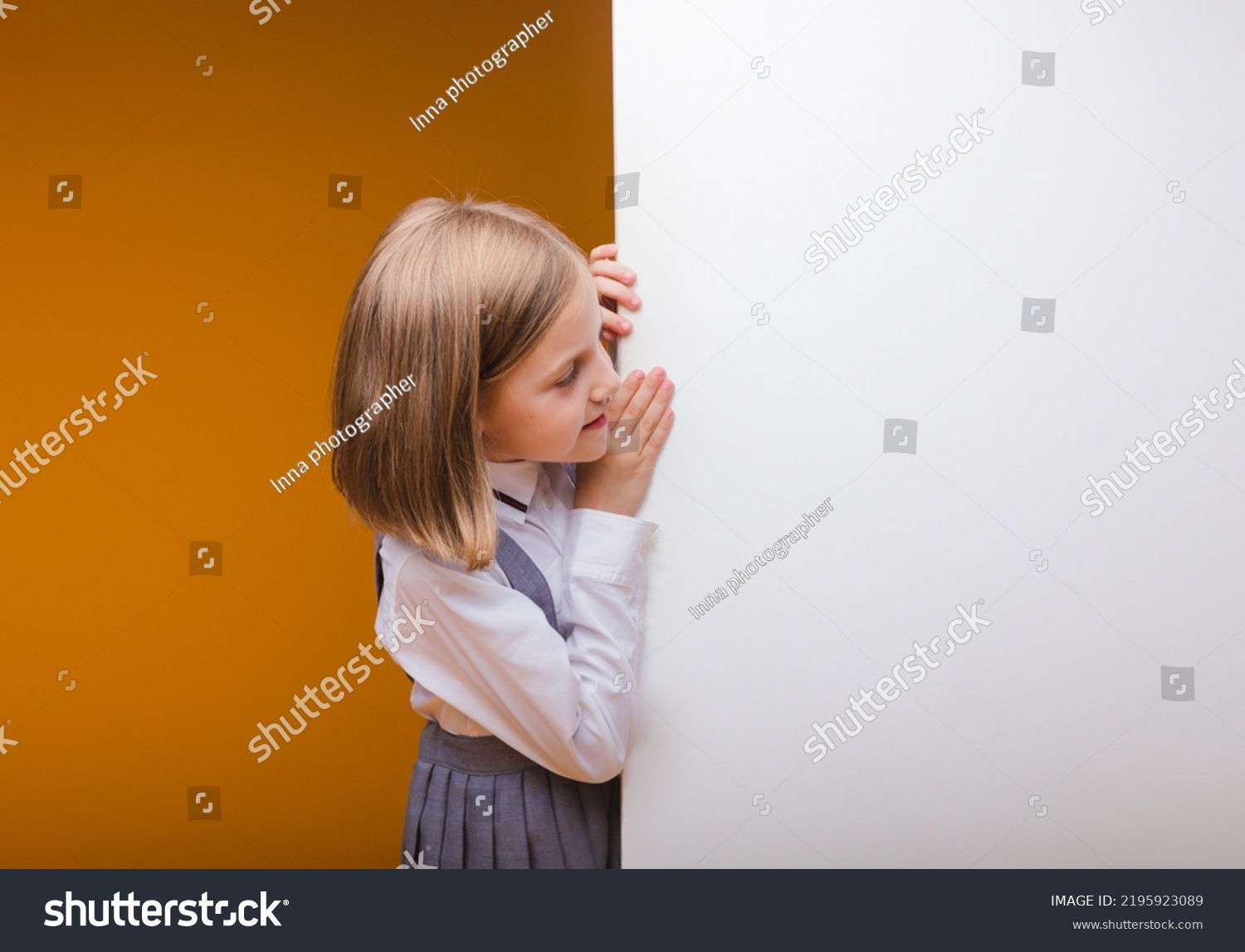 A smiling schoolgirl stands behind a white blank panel highlighted on a yellow background. An empty space for text looks out from behind the banner.
