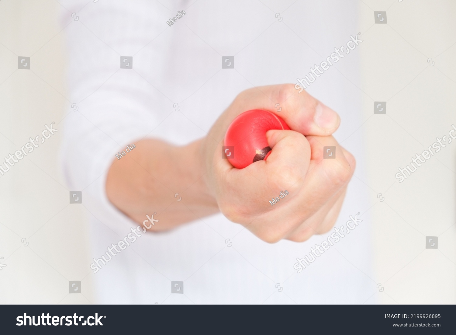 Hands of man with a gentle personality He exhibits stressful behavior from work and he squeezes the yellow ball expressing emotion anger displeasure. Medical concepts. soft focus