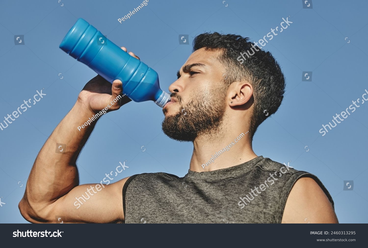 Man water bottle and drink with blue sky in nature outside and hydration for exercise and thirsty. Fitness healthy and cardio workout for male person athlete and park for sports and run training