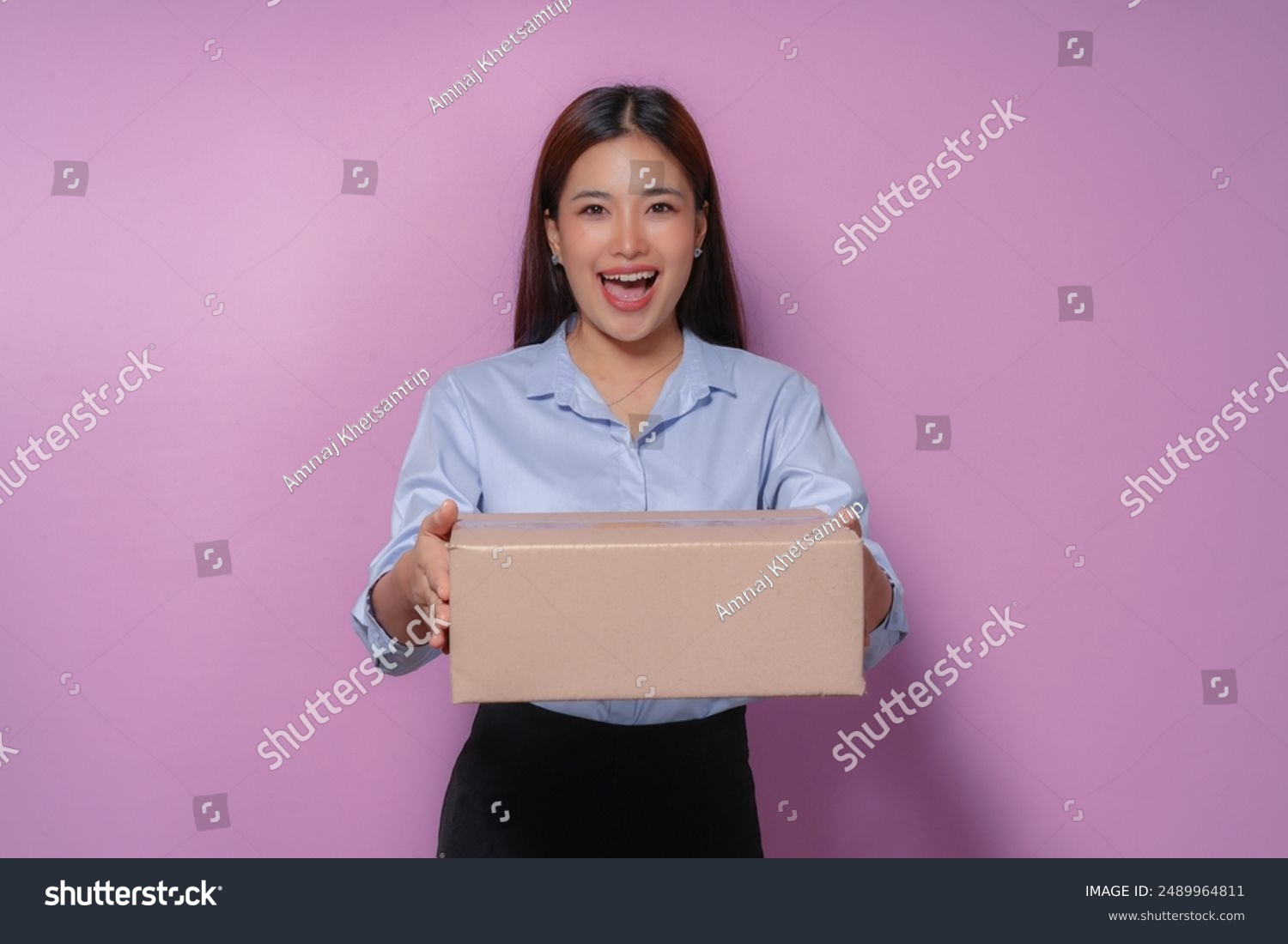 Excited young woman holding a package happy with fast delivery service purple background online shopping satisfaction