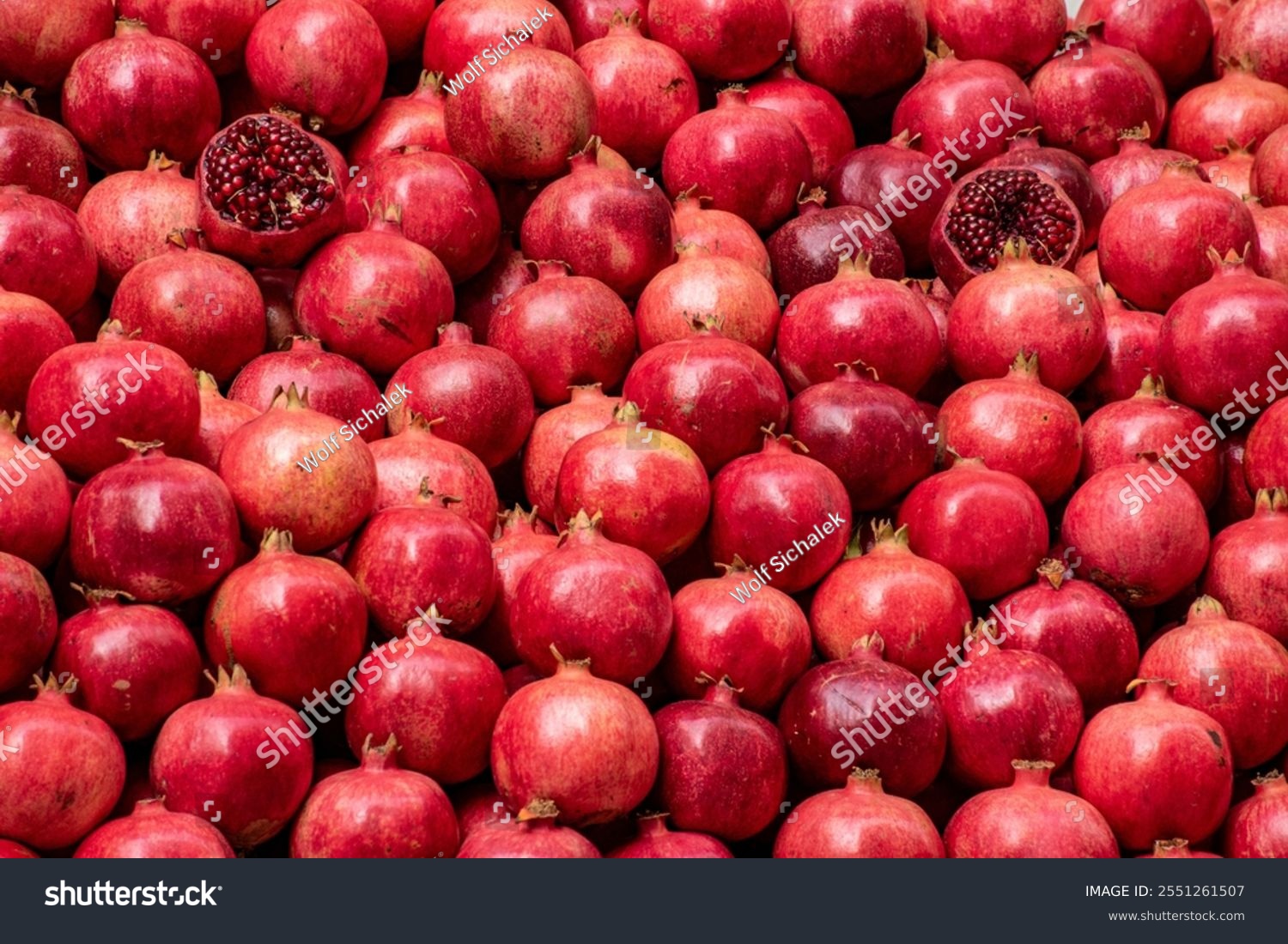 Pomegranates whole and sliced ​​as background