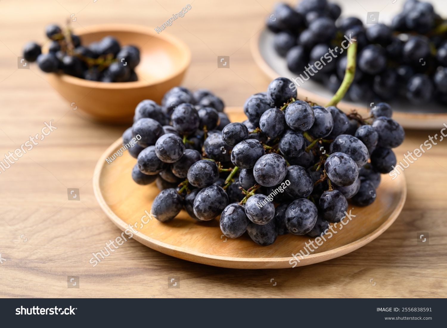 Black grapes on wooden plate  Seedless grapes