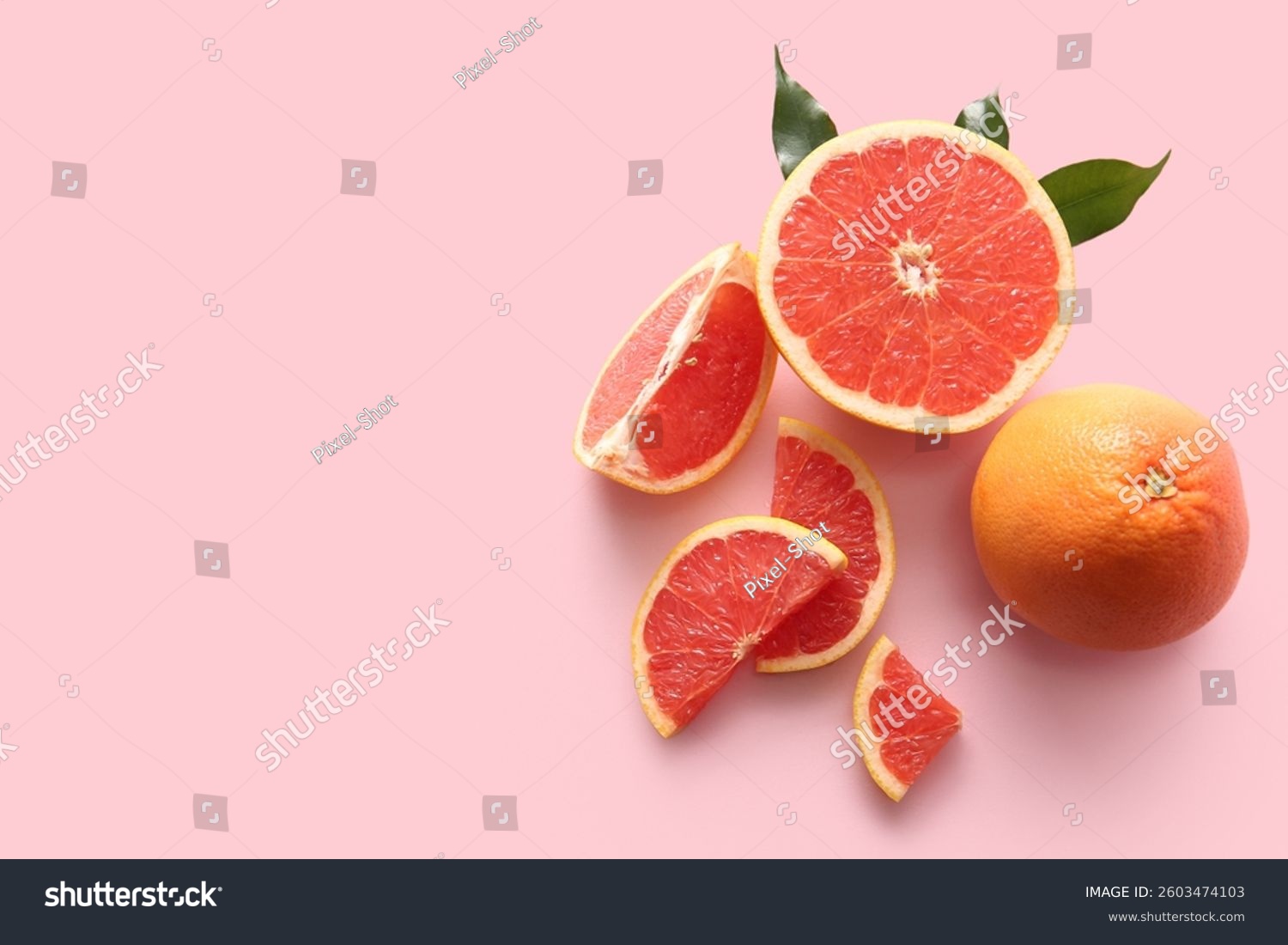 Fresh ripe grapefruits and leaves on pink background