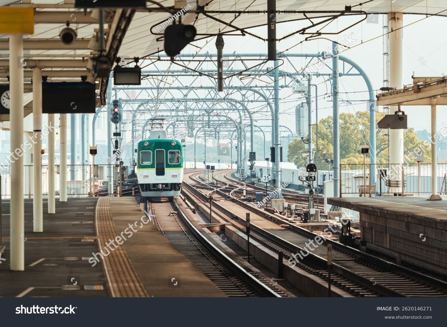 Electric railway iconic train with intricate metal structure and multi tracks arrival to station at Kyoto Japan