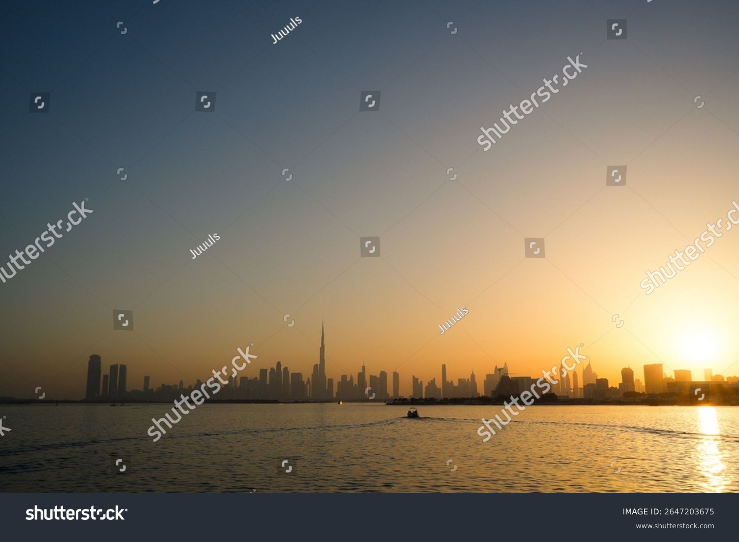 Golden sunset over the sea with Burj Khalifa rising in the distance against Dubai’s skyline.