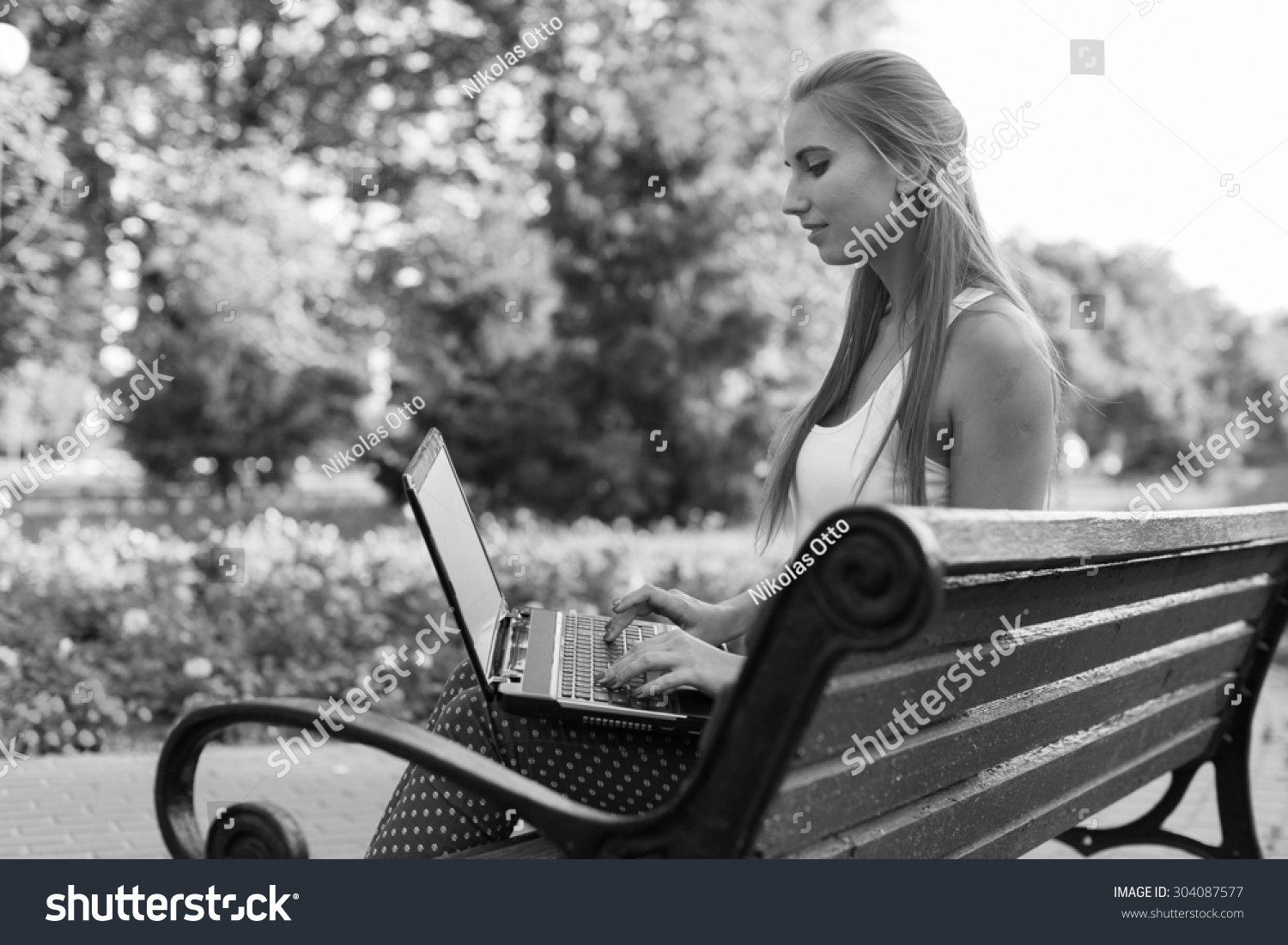 Black and White. BW. Young woman using tablet laptop notebook reading books outdoor smiling.