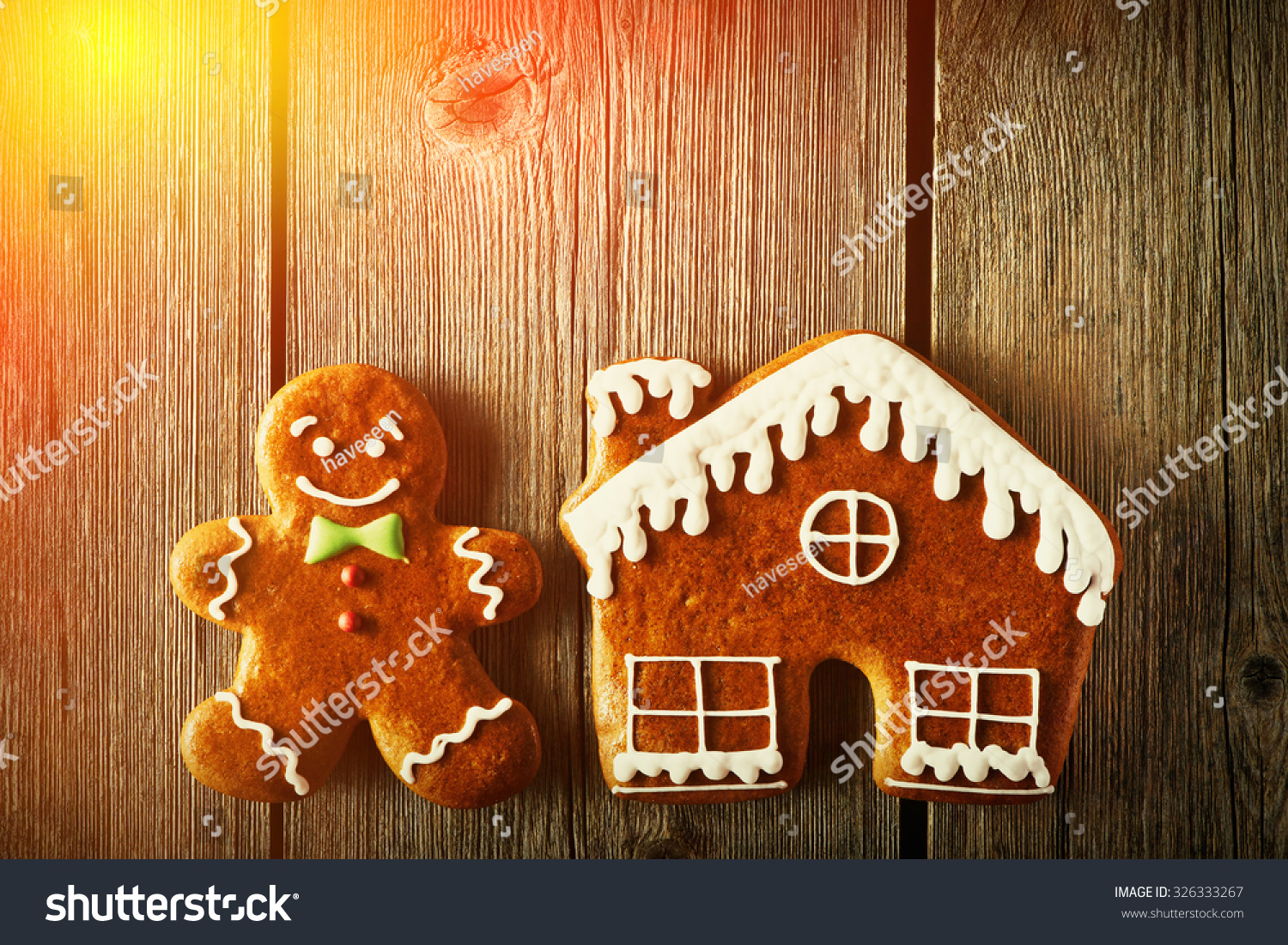 Christmas homemade gingerbread man and house on wooden table