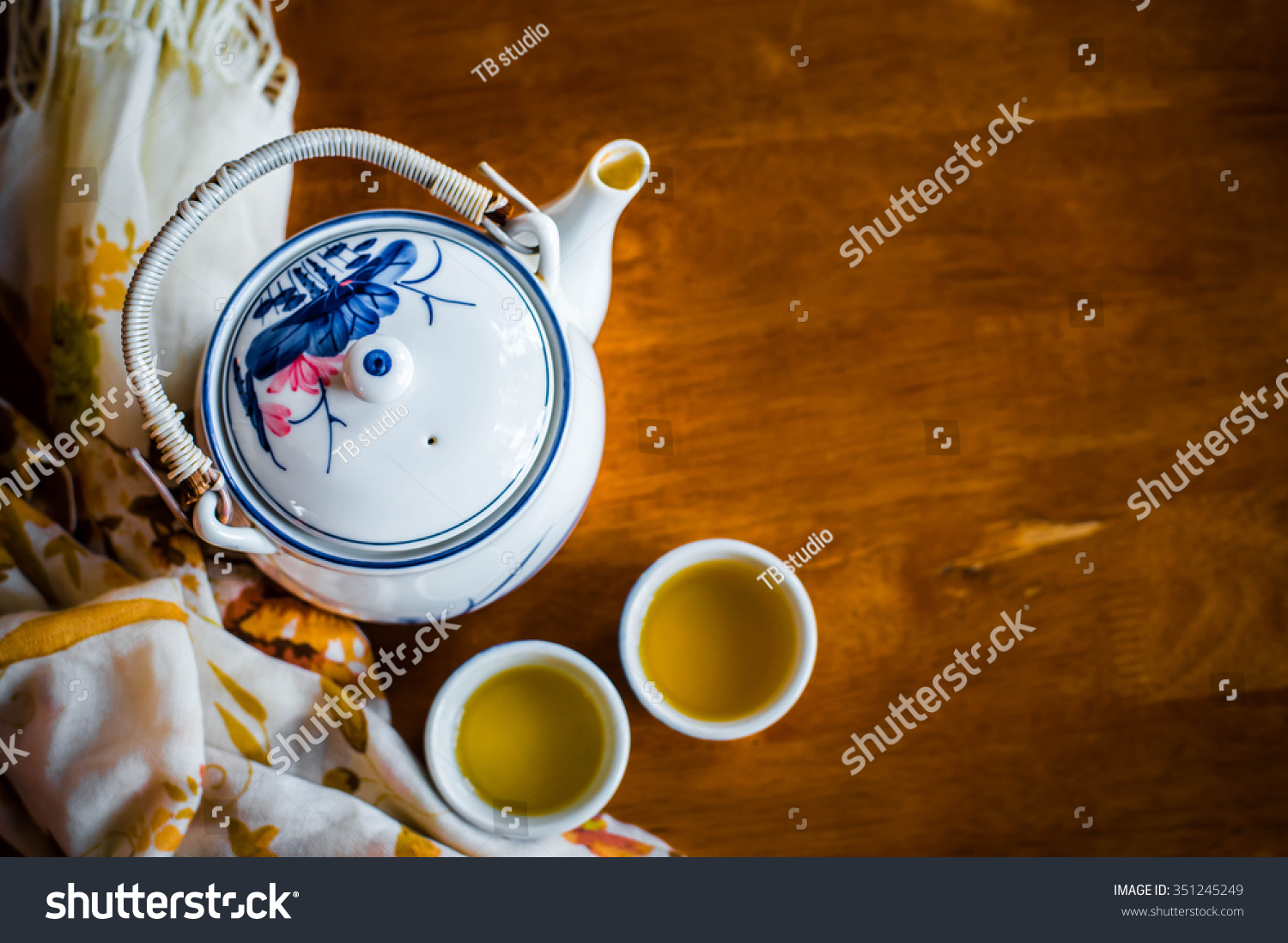 Image of traditional eastern teapot and teacups on wooden desk