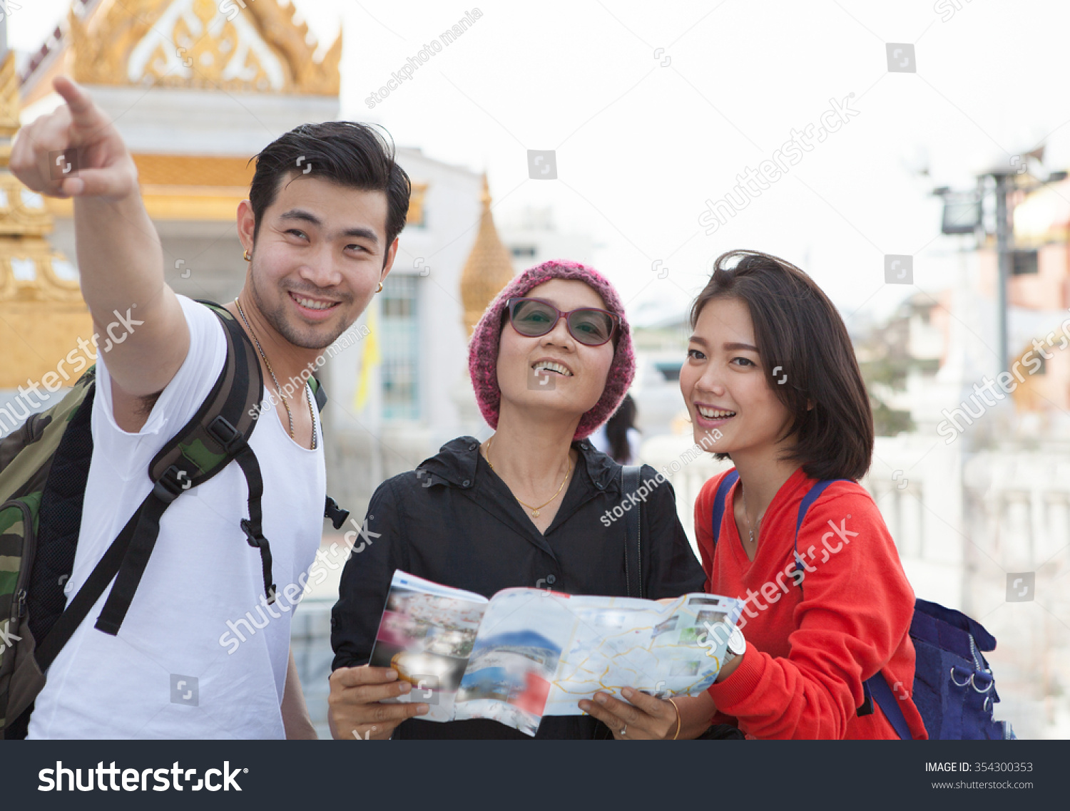 traveling man woman and senior tourist holding travel guide book in hand pointing to destination for visiting