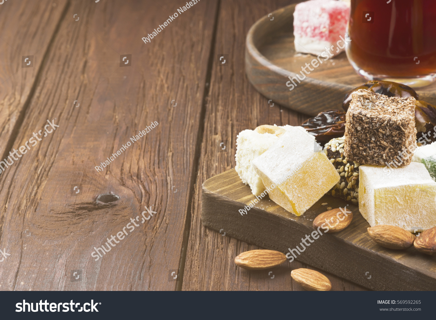 Black tea oriental sweets dates and nuts on a dark wooden background. Copy space. Food background. Toning.