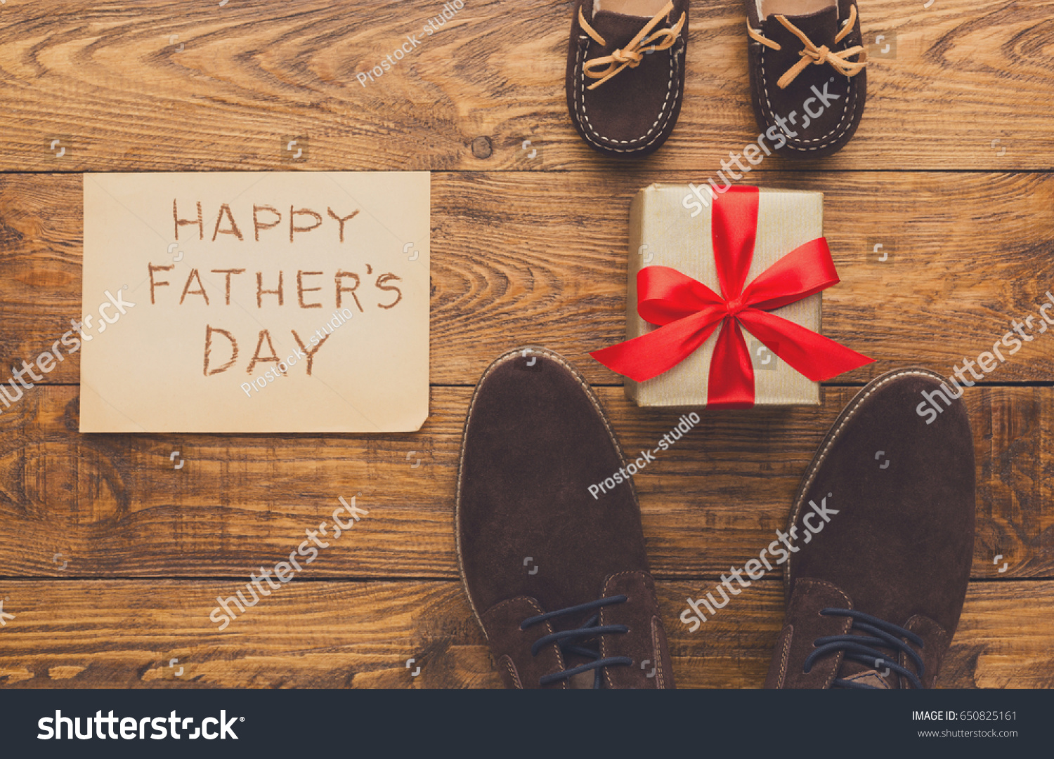 Happy Fathers Day card background on rustic wood with male and child shoes  copy space