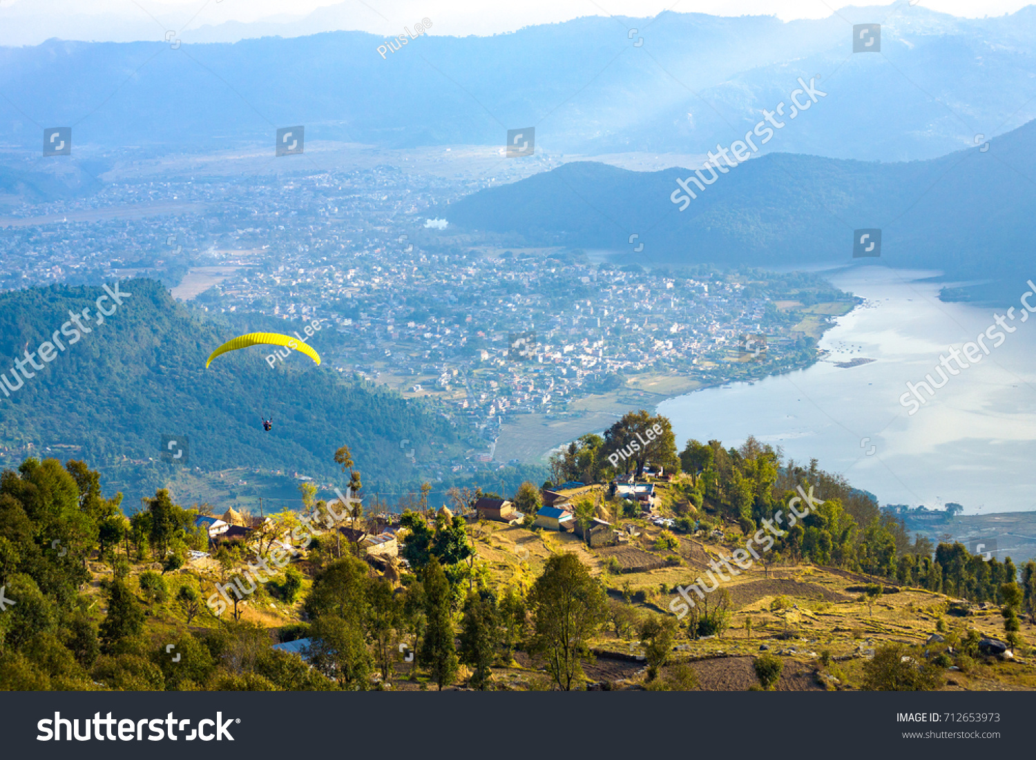 High angle aerial view of paraglider descending onto Pokhara and Phewa Lake seen from Sarangkot Nepal