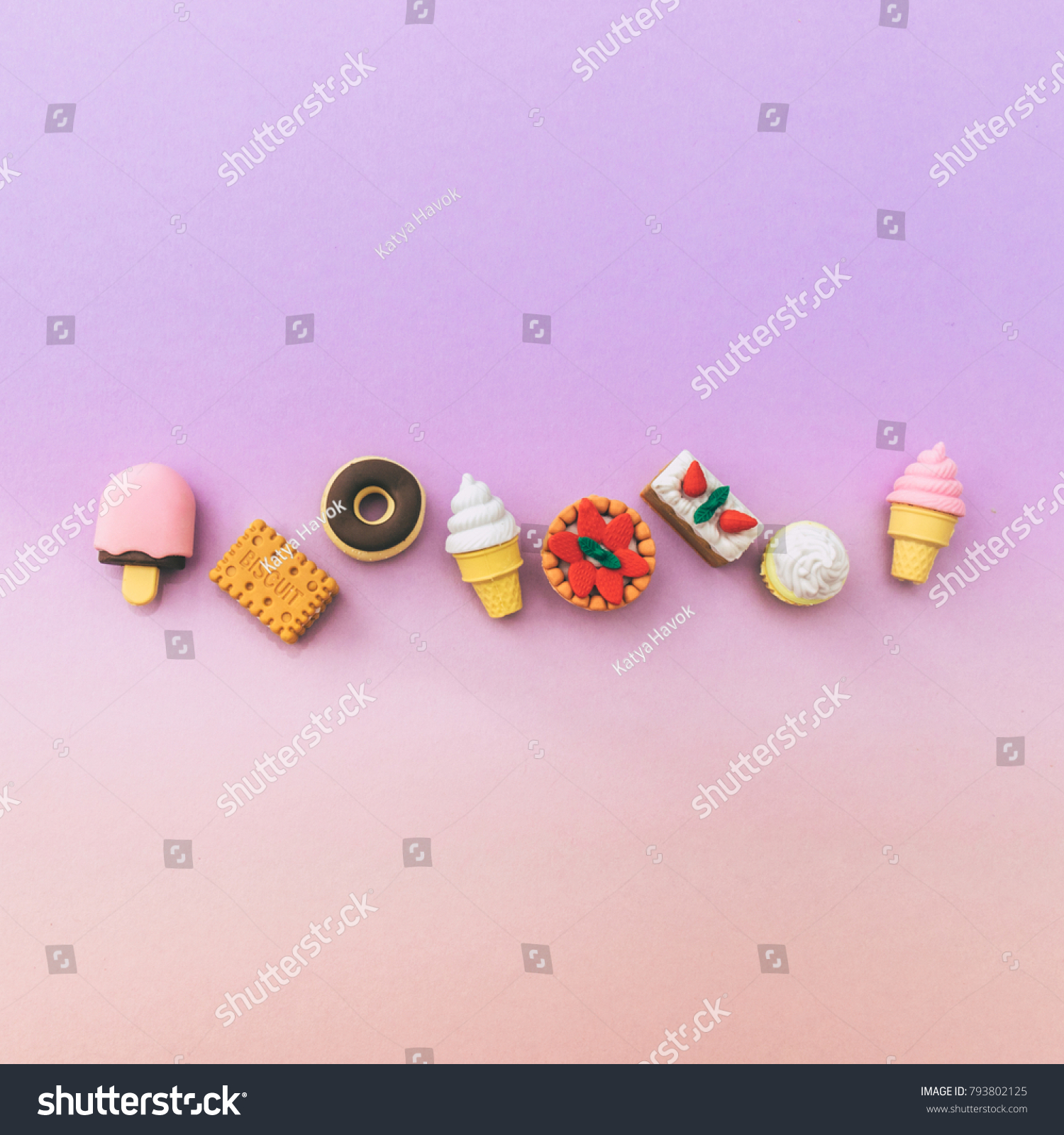 miniature sweets: ice cream  cake  cupcake  donut  pastries laid out in a line on a gradient  background. the concept of food and dessert. fashion minimal. pastel colors